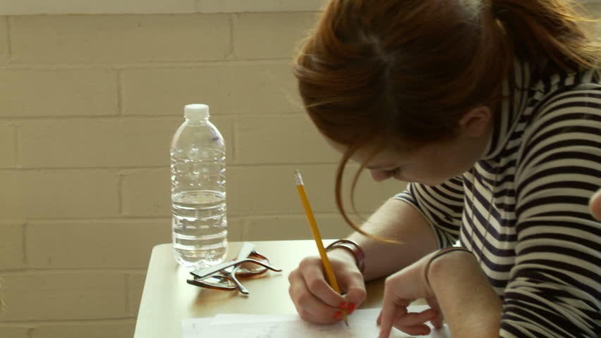 Girl draws on a piece of paper during class.