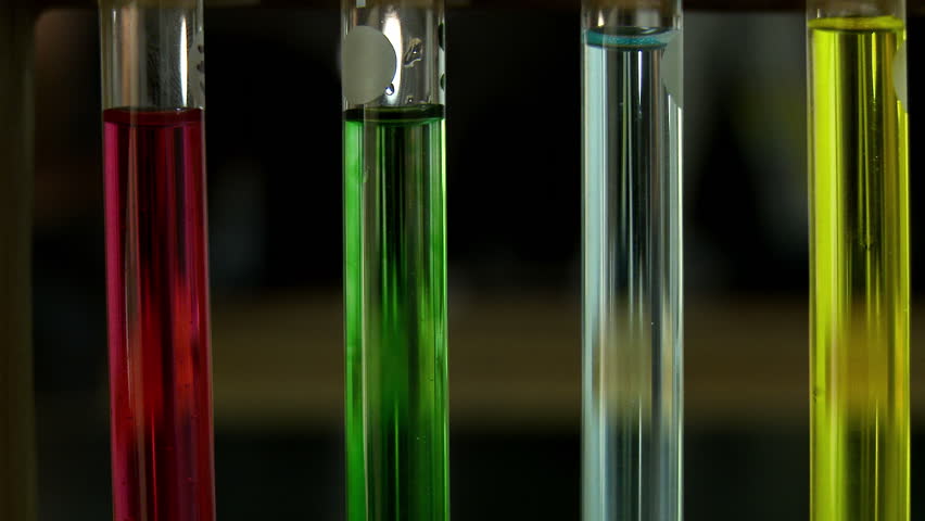 Four test tubes of colored liquid in sharp focus with soft focus laboratory