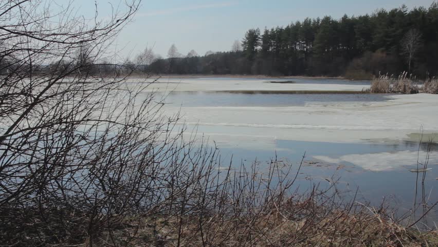 Panoramic view of the lake in spring with ice and snow.