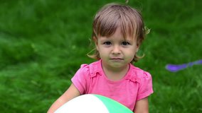 Close-up of a lovely toddler holding a ball outdoors