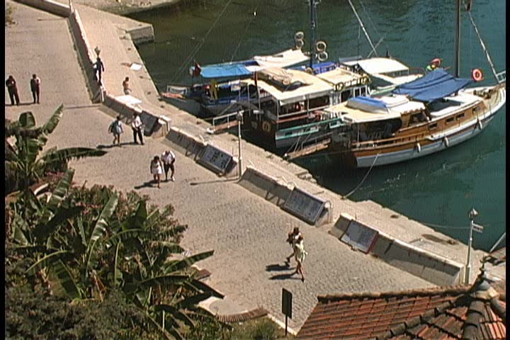 People strolling along side a harbor in Antalya, Turkey