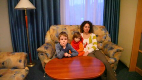 Mother and two children watch TV 