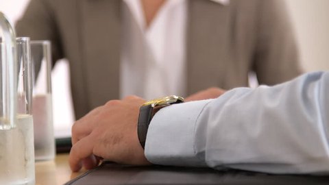 Businessman checking his watch in a meeting