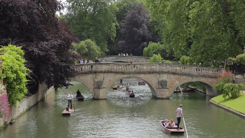 CAMBRIDGE, CAMBRIDGESHIRE/ENGLAND - JUN 27: Unidentified people punt on River Cam, Clare Bridge in background on Jun 27, 2013 in Cambridge. Punting has been a Cambridge tradition for over 100 years.