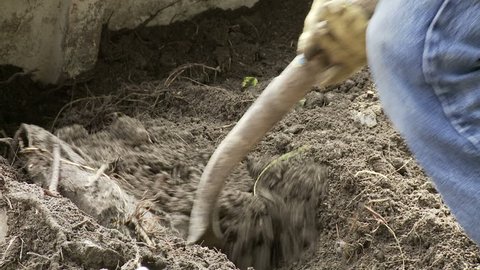 Detail of soil being shoveled out of a pile.