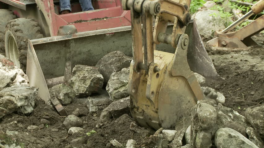 Close up of a mechanical shovel moving rocks into a skip loader.