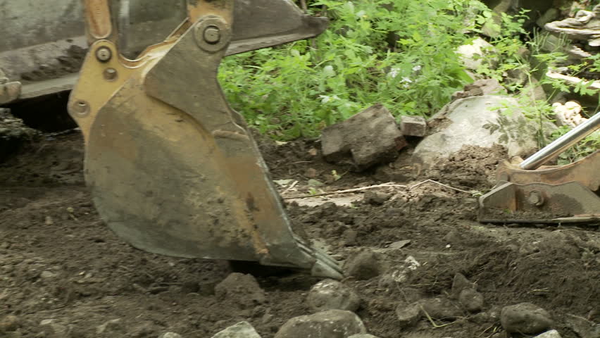 Close up of a mechanical shovel nudging rocks into a skip loader.  Looks a bit