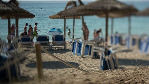 shot of a beach in mallorca with deck chairs. this is a tilt focus shot with the people out of focus