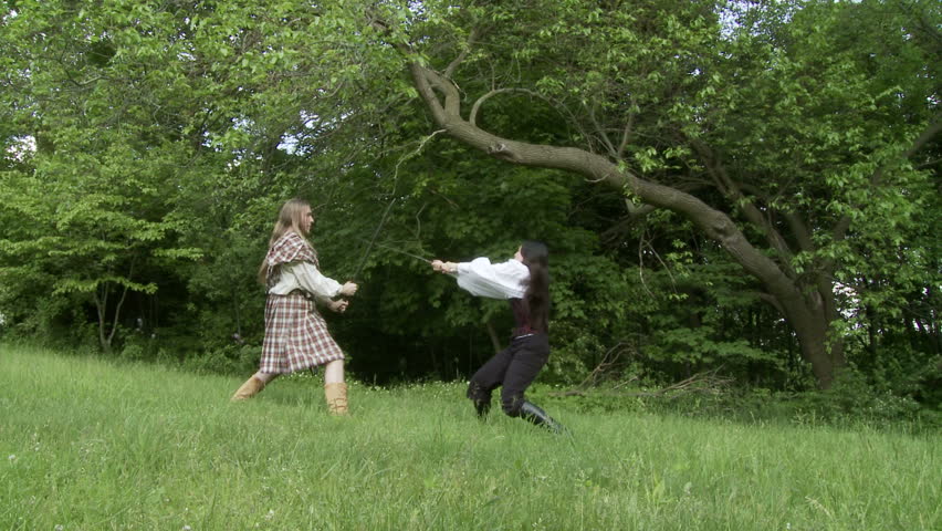 Wide view of sword fight between a man in a kilt and an asian girl in a corset,