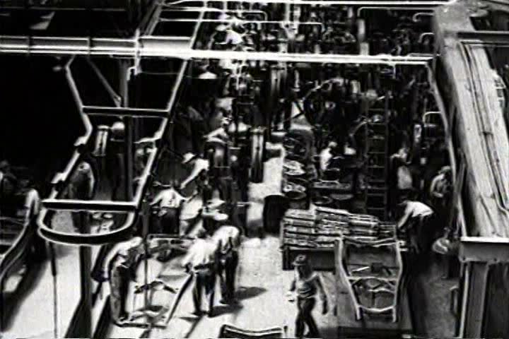 1930s - Great long traveling aerial shot over a factory with workers in 1932.