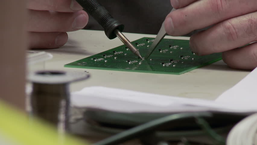 Short dolly move revealing close up of a circuit board being put together.