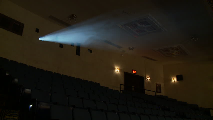 View of the light beam of a 35mm projector running in a semi-darkened movie