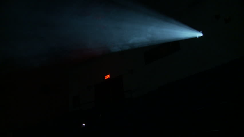 Side view of the light beam from a 35mm projector running in a darkened movie