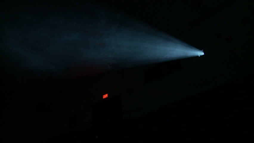 Side-on view of the light beam of a 35mm projector running in a darkened movie