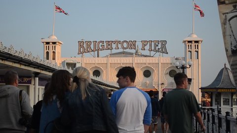 BRIGHTON, UNITED KINGDOM - JULY 12, 2013: People enjoying the evening sunshine on Brighton Pier on July 12.  Temperatures reached over 30 degrees Celsius over the weekend in Britain. 