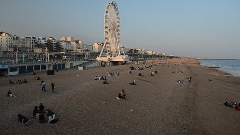 BRIGHTON, UNITED KINGDOM - JULY 12, 2013: People enjoying the evening sunshine on Brighton Beach on July 12.  Temperatures reached over 30 degrees Celsius over the weekend in Britain. 