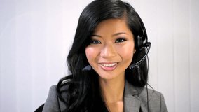 Asian Chinese businesswoman wearing headset for discussion with wireless video uplink to meet with fellow business people