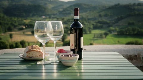 Table with wine and appetizer on italian landscape