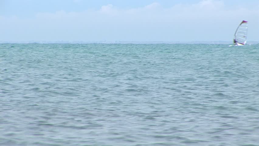 Board with a sail on water. It floats on waves of the black sea