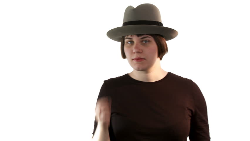 Young woman wearing a fedora style hat, shoots with her fingers at the camera.