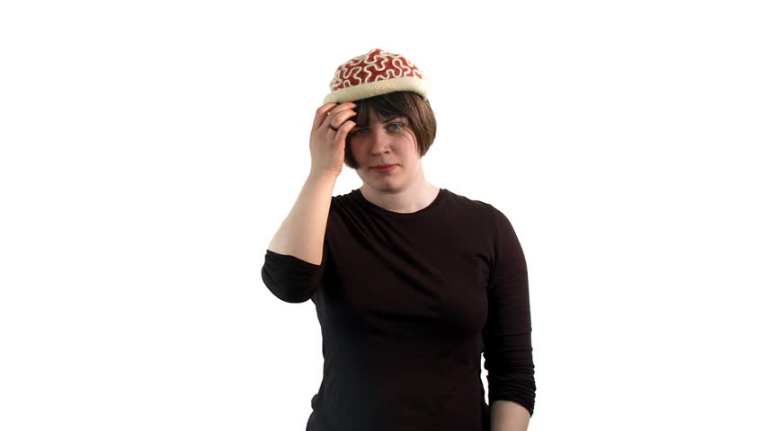 Mid shot of a young woman wearing a knitted cap that resembles red brains.  She