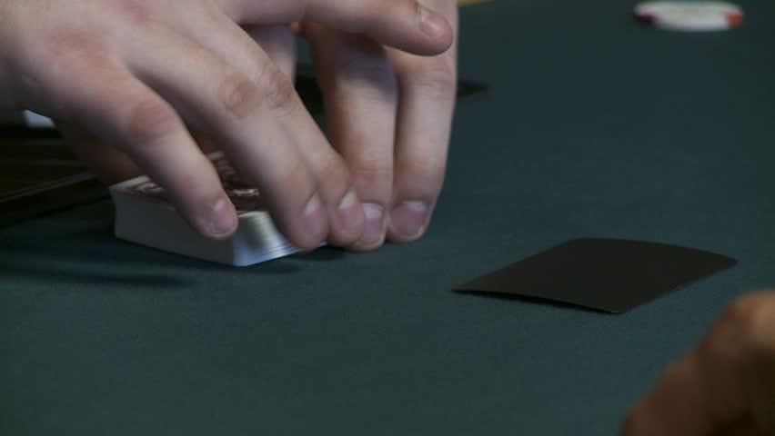 Close up on cards being shuffled during a poker game.  Raised viewpoint, looking