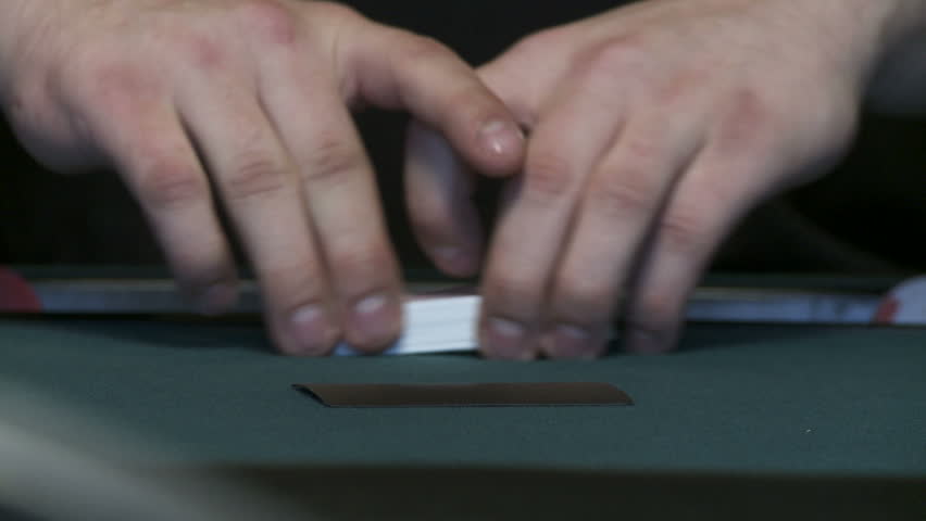 Close up on cards being shuffled during a poker game.  Low viewpoint, almost on