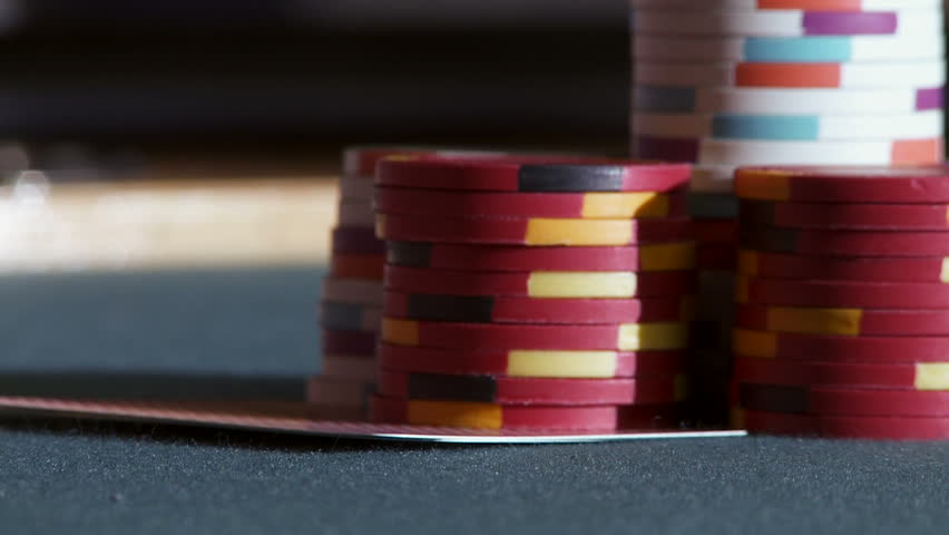 Close up on pair of aces being checked in front of a pile of casino chips during
