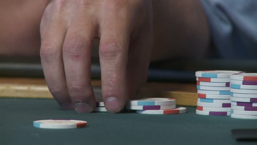Close up on hands playing with a stack of poker chips.  Slow motion, recorded at