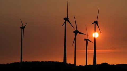 Wind engines in rural scene with setting sun
