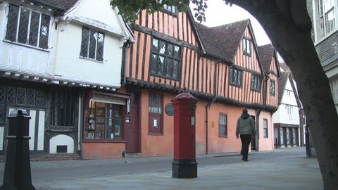 Ipswich, England - June 2013: A pedestrian walks past the Victorian post box and ancient wooden framed buildings in Silent Street.