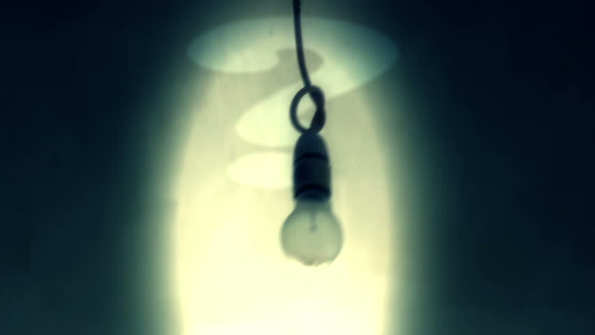 Unlit light bulb moving side to side with a question mark projected behind it