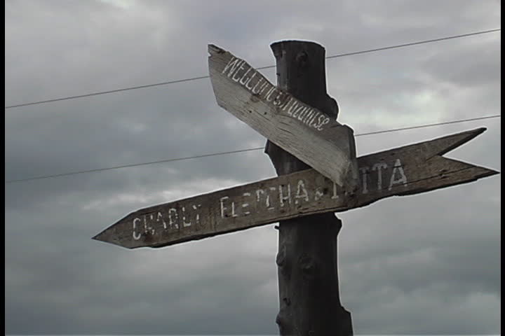 Weathered signpost under sky full of gray clouds in Albuquerque, New Mexico.
