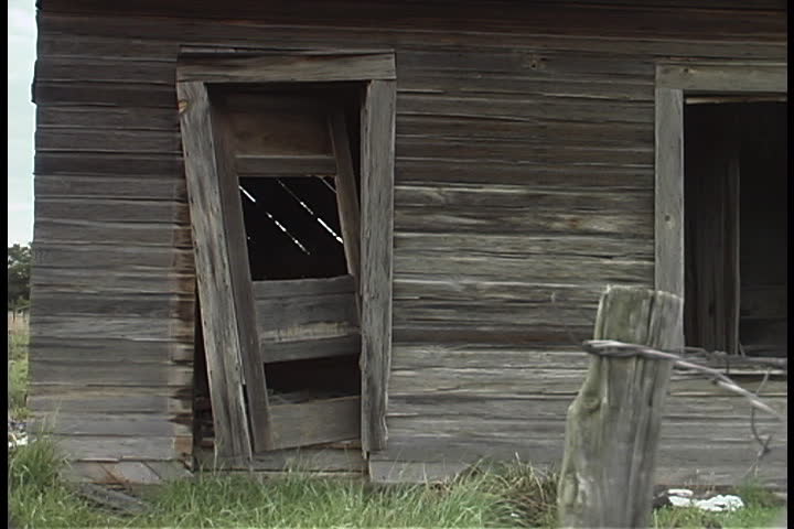 Abandoned old wooden house with broken door frame and no glass in window in Albuquerque, New Mexico.