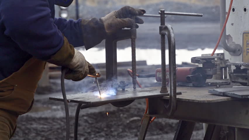 Workman welding steel plates slow motion