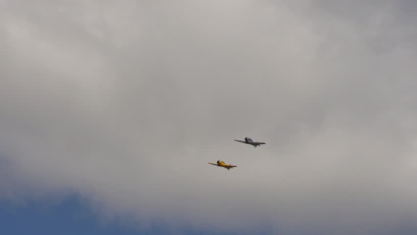 A pair of restored World War 2 aircraft in cloudy sky