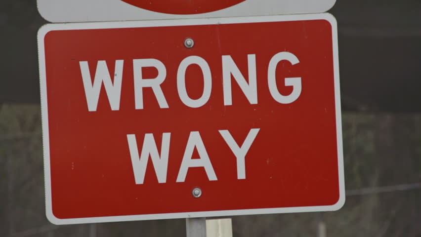 Rack focus to red Wrong Way sign on an exit ramp