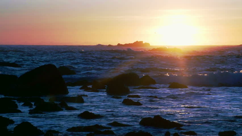 Beautiful setting sun over Oregon coast waves and rocks