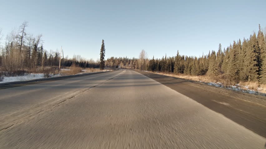 Automobile POV driving north on rural highway in Alaska