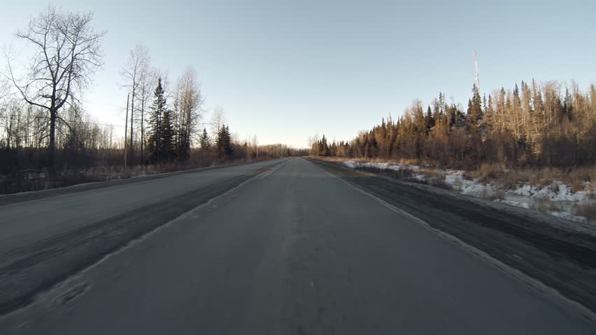 Low angle driving POV, driving north on rural two-lane road in Alaska