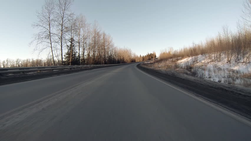 Low angle driving POV, driving north on rural highway in Alaska
