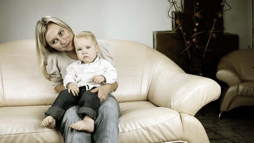 Mother with son on sofa watch TV