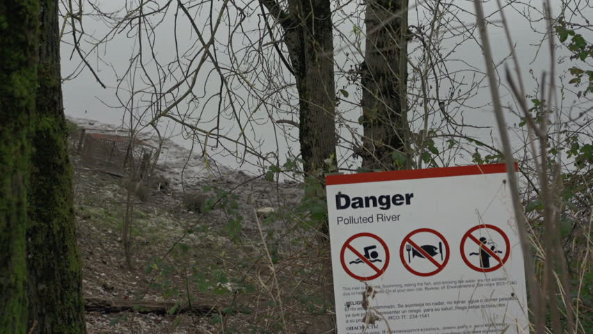 Polluted River with Danger Sign