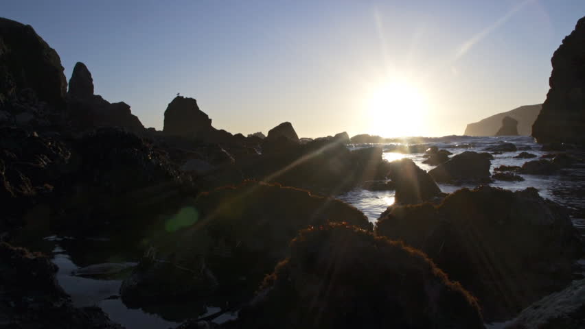 Low angle sunset shot of incoming tide through rocks with a clear sky at Harris