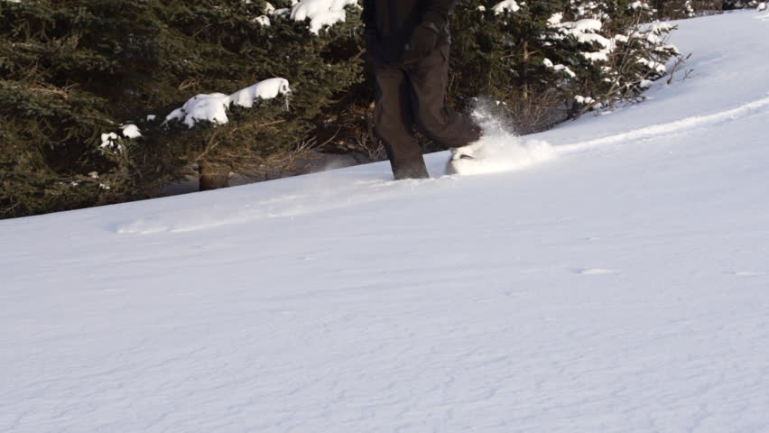 Man takes hike in snow shoes in slow motion
