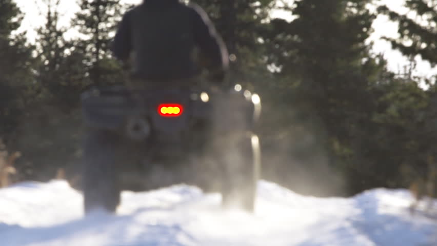 Rider on ATV in snowy field in Alaska