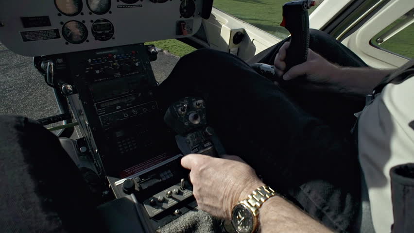 Handheld POV of pilot's hands as he lands helicopter