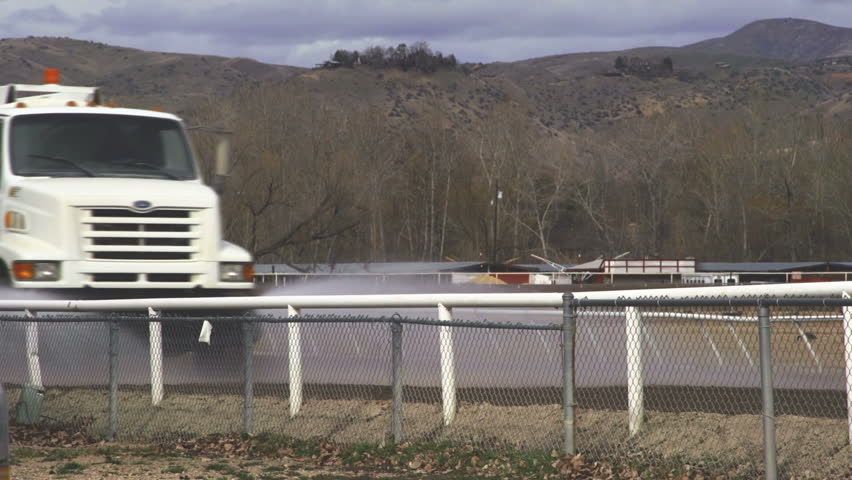 BOISE, ID - UNKNOWN - A water truck sprays water on an earthen race track in