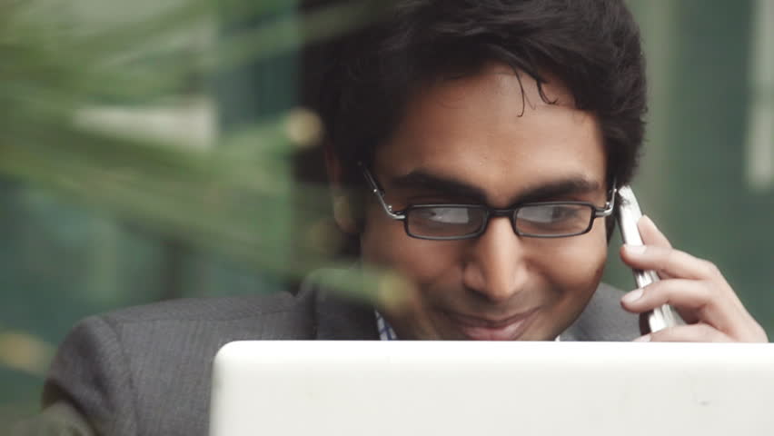 Shot of a businessman using a laptop while talking on mobile Royalty-Free Stock Footage #4324583