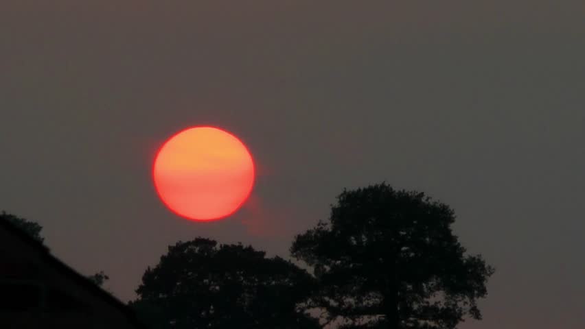 Red hot sun set against silhouette  background
